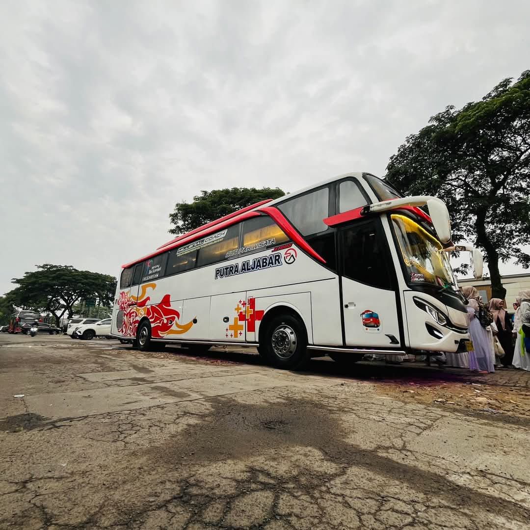 Bus pariwisata Putra Al Jabar berwarna putih dengan aksen merah